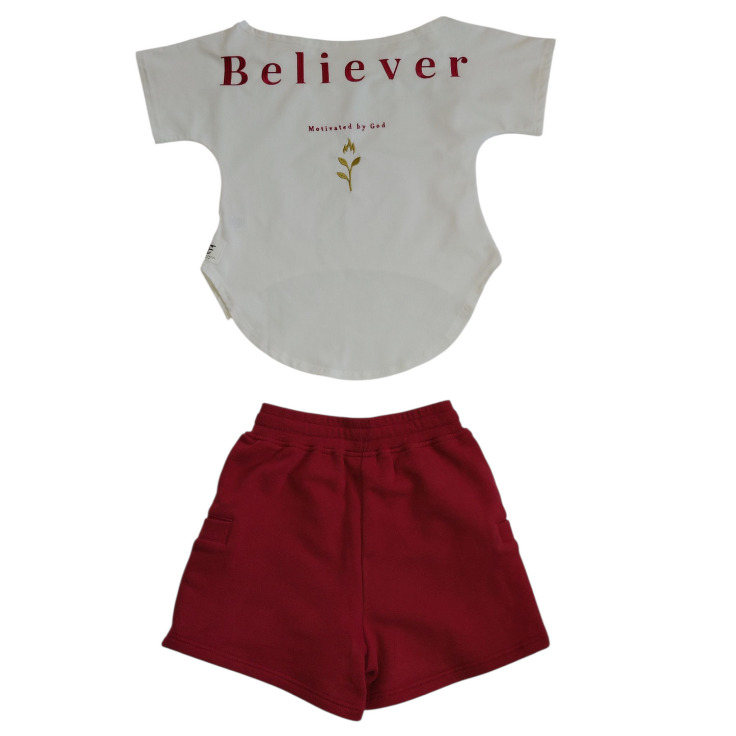 Back of white ‘Believer’ shirt with gold plant graphic and ‘Motivated by God’ text, paired with back of solid red shorts.