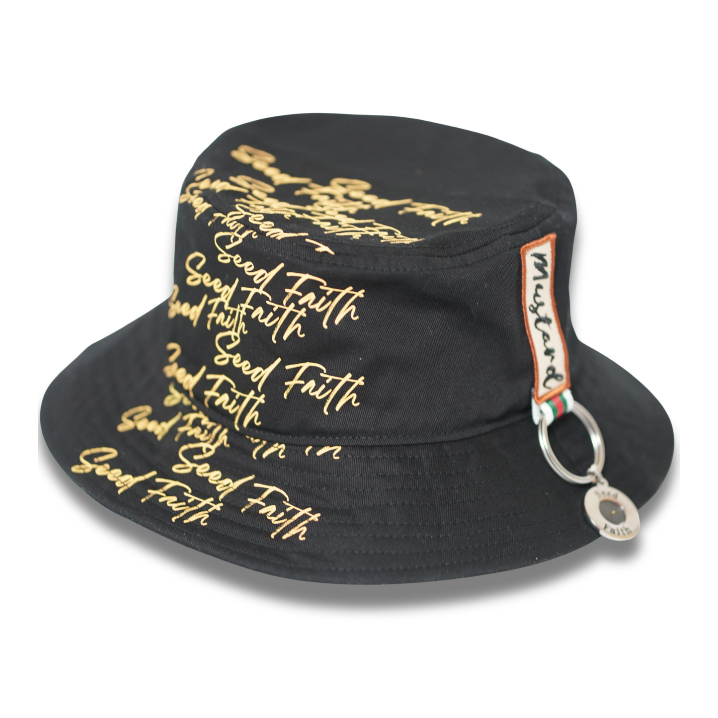 Close-up side view of the black “Grounded & Rooted” Mustard Seed Faith bucket hat by Cotton Faith, featuring gold “Seed Faith” script across the crown and a woven Mustard tag with attached chrome ring and pendant.