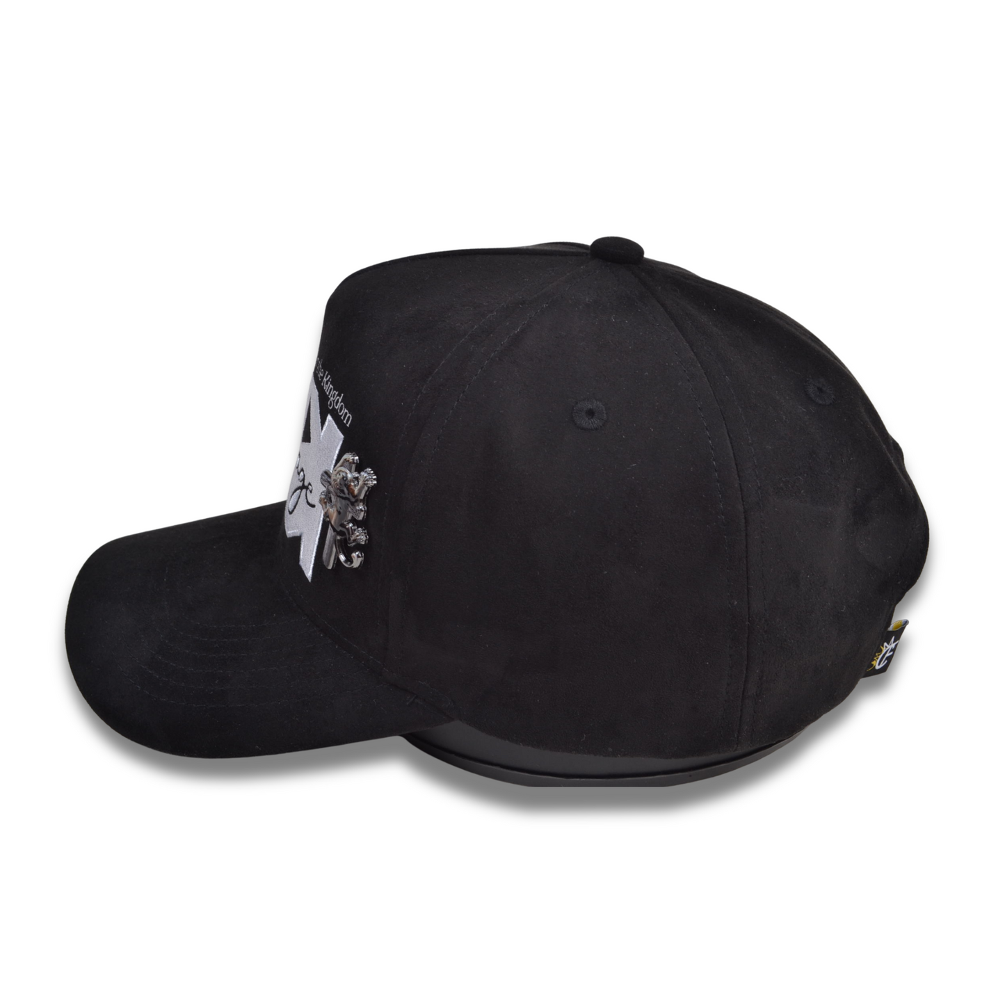 Side view of the Kingdom Heritage black suede hat featuring a raised silver metal lion-on-the-cross emblem attached near the front panel, with embroidered “Kingdom Heritage” logo.