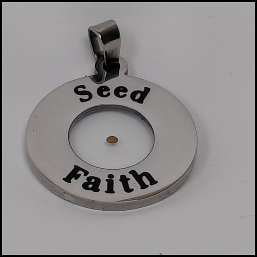 Close-up image of a circular stainless-steel pendant engraved with the words 'Seed Faith.' A small mustard seed is encased in clear resin at the center, symbolizing faith inspired by Matthew 17:20.